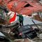 A man gestures towards a search and rescue team while looking for victims in the earthquake and liquefaction affected Balaroa neighbourhood in Palu